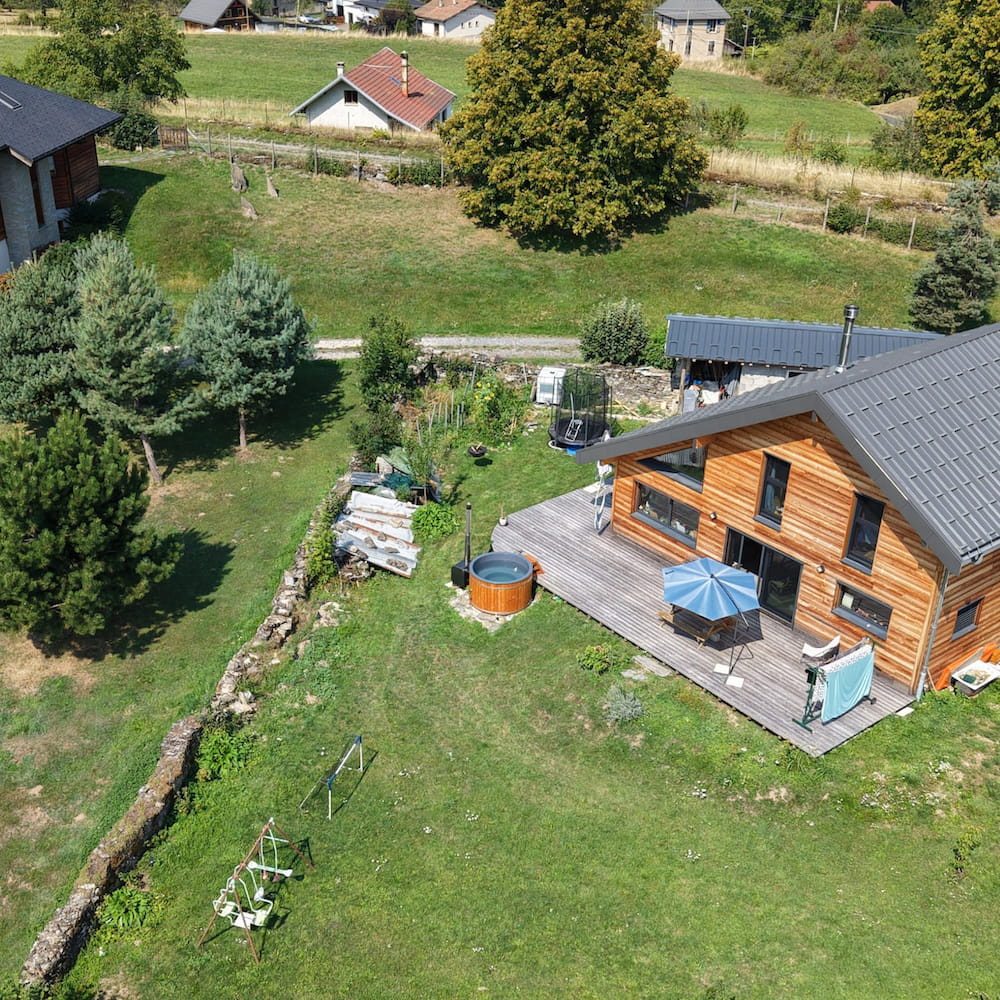 Vue aérienne d'un bain nordique extérieur dans un jardin près d'une maison en bois en Isère