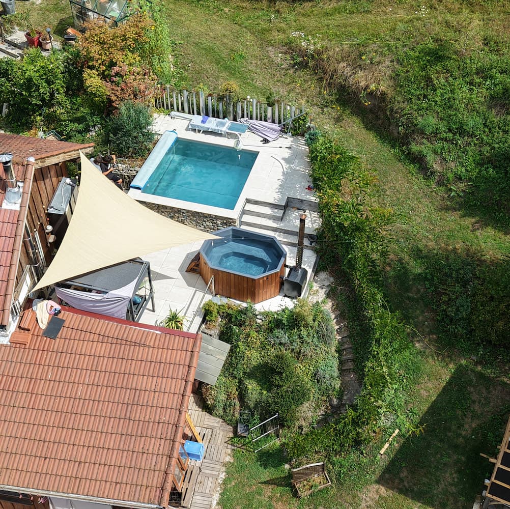 Vue aérienne d'un bain nordique octogonal à côté d'une piscine dans un jardin en Isère