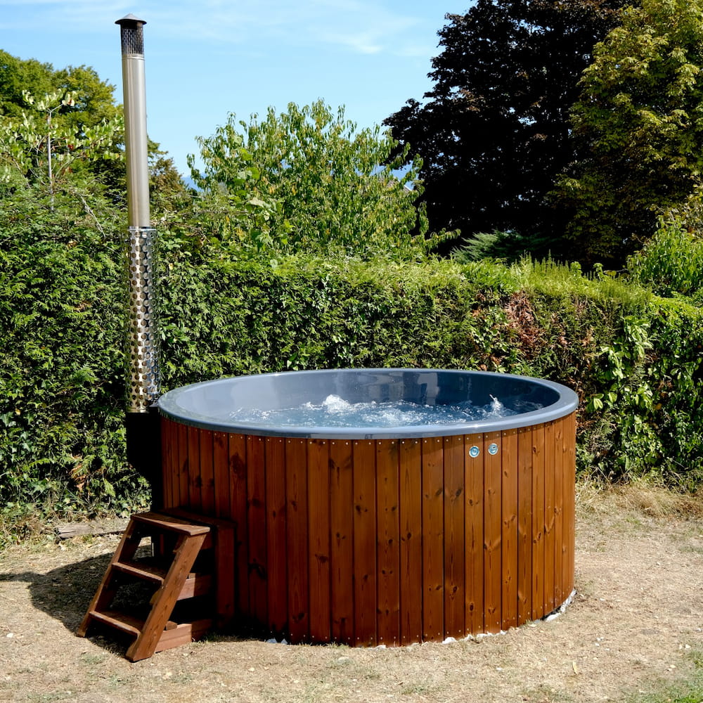 Bain nordique en bois avec poêle intégré et bulles dans un jardin en Isère