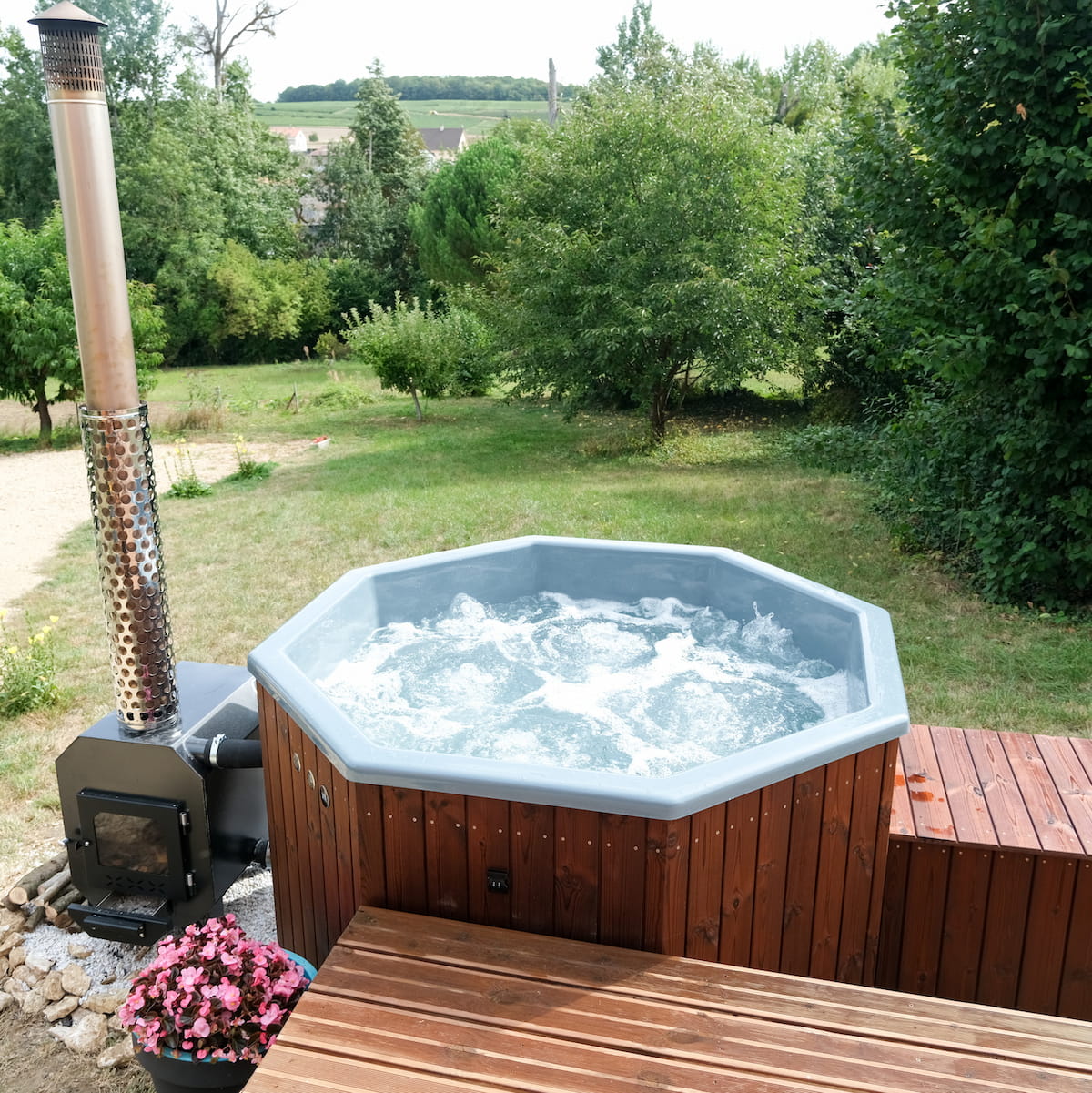 Vue rapprochée d'un bain nordique octogonal en bois avec système à bulles