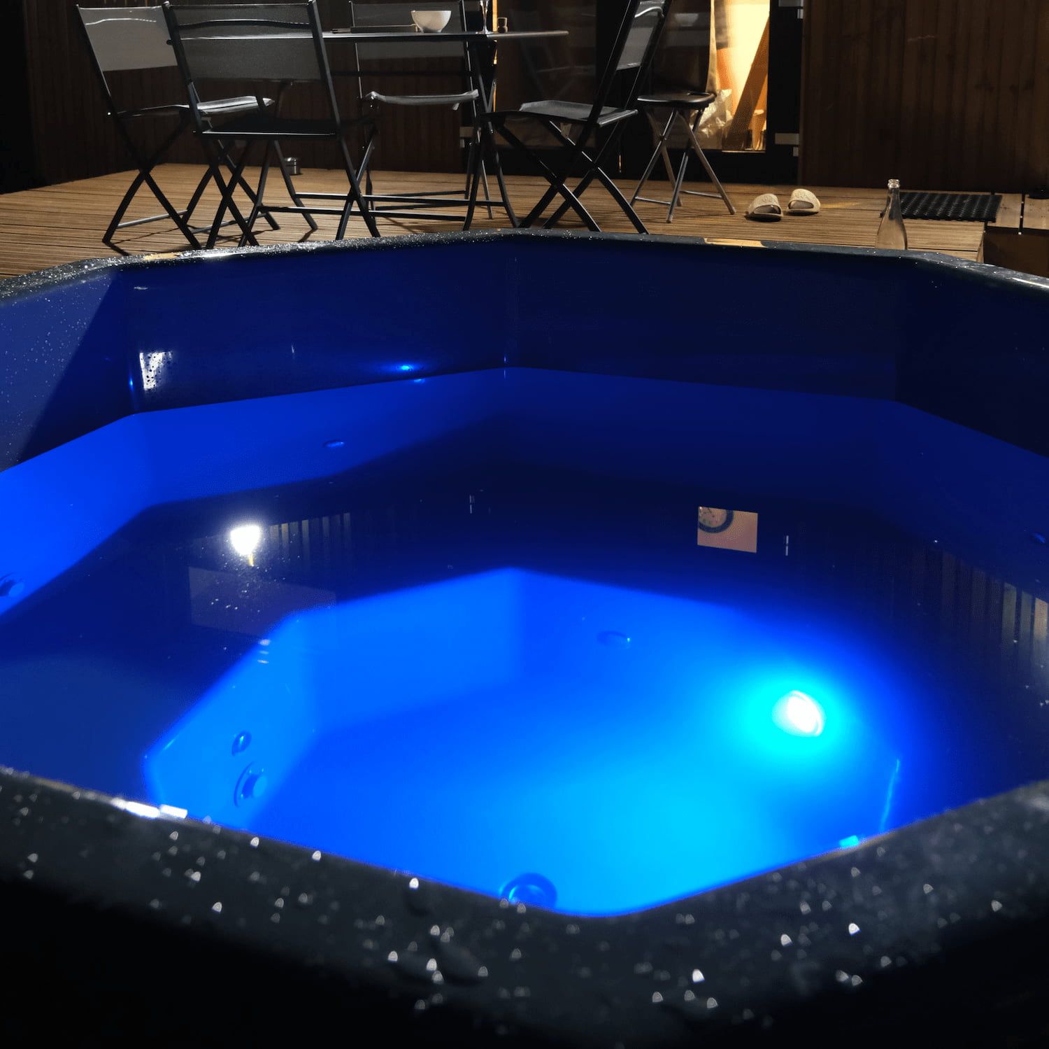 Éclairage LED bleu à l'intérieur d'un bain nordique octogonal SKADI de nuit